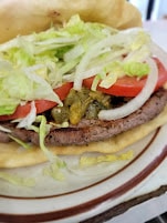 Grilled burger with lettuce, tomato and onion